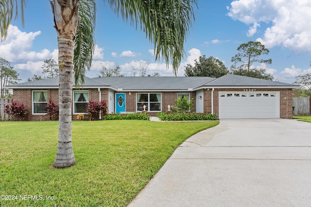 ranch-style house featuring a front yard and a garage