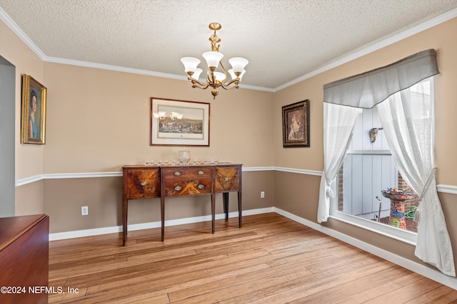 dining room with an inviting chandelier, ornamental molding, a textured ceiling, and light wood-type flooring