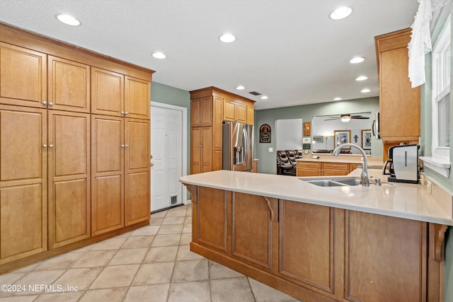 kitchen featuring sink, a textured ceiling, kitchen peninsula, stainless steel fridge, and ceiling fan