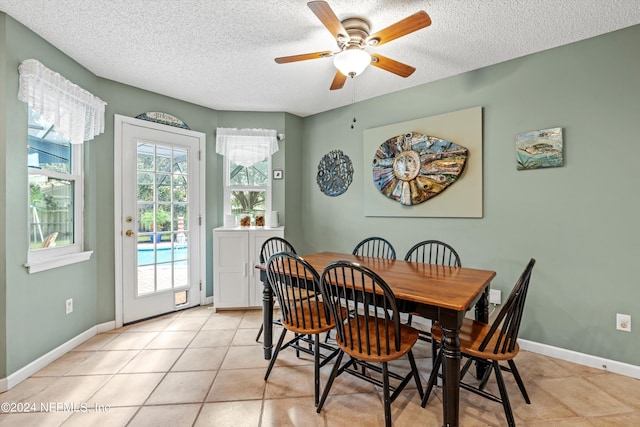 dining room with a textured ceiling, light tile patterned floors, and ceiling fan