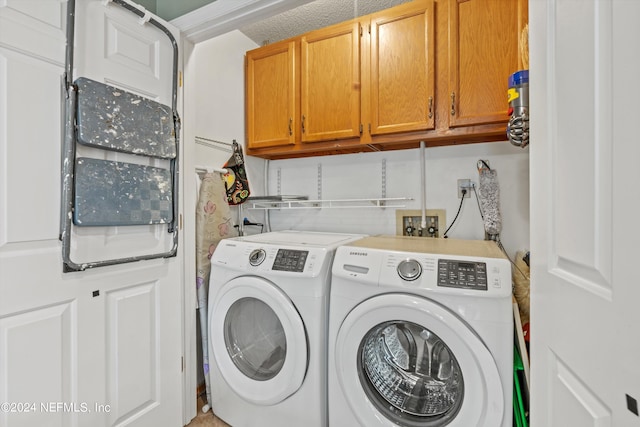 washroom featuring cabinets and washer and clothes dryer