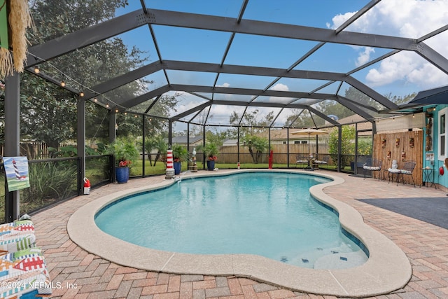 view of swimming pool featuring a patio area and a lanai