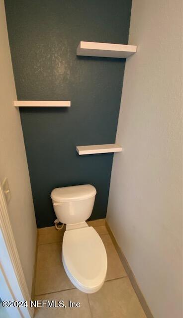 bathroom with toilet and tile patterned floors