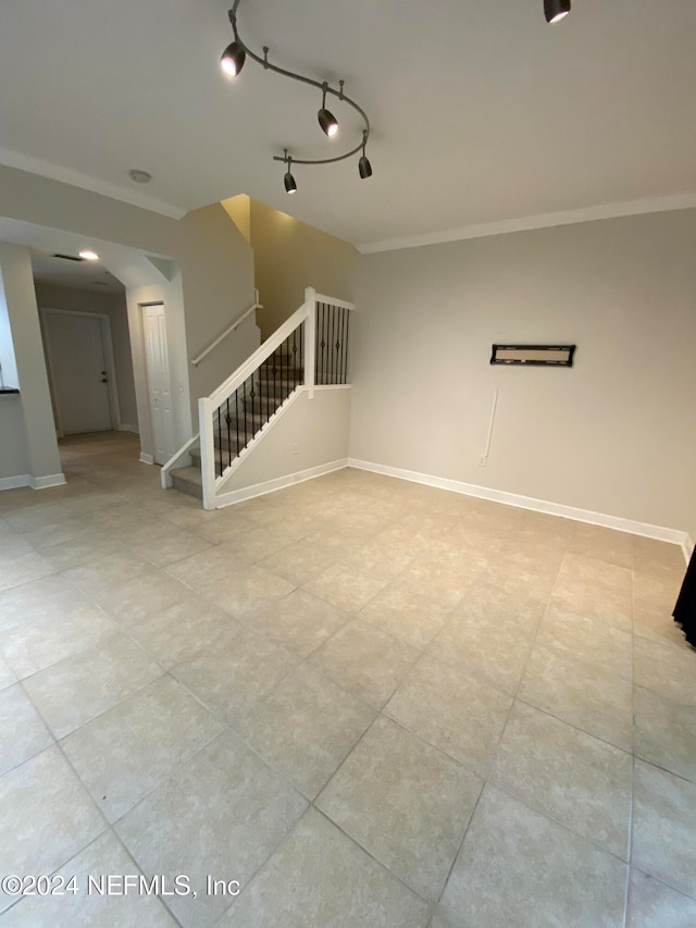 empty room featuring ornamental molding and track lighting