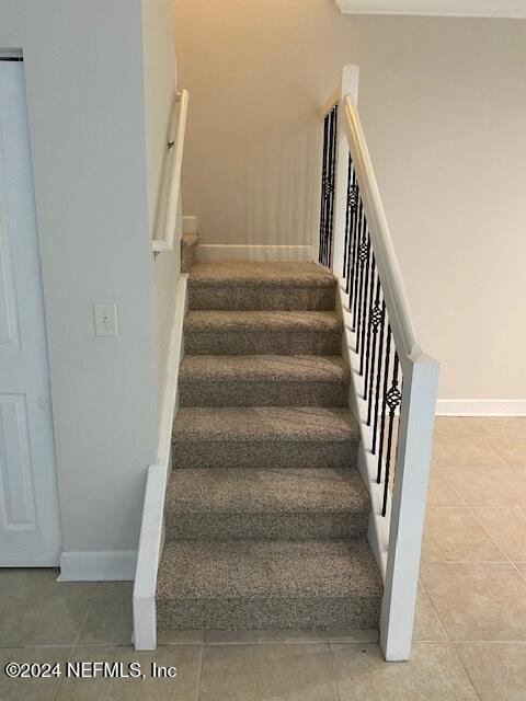 stairway featuring tile patterned floors