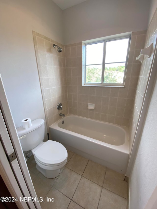 bathroom featuring tile patterned floors, toilet, and tiled shower / bath combo