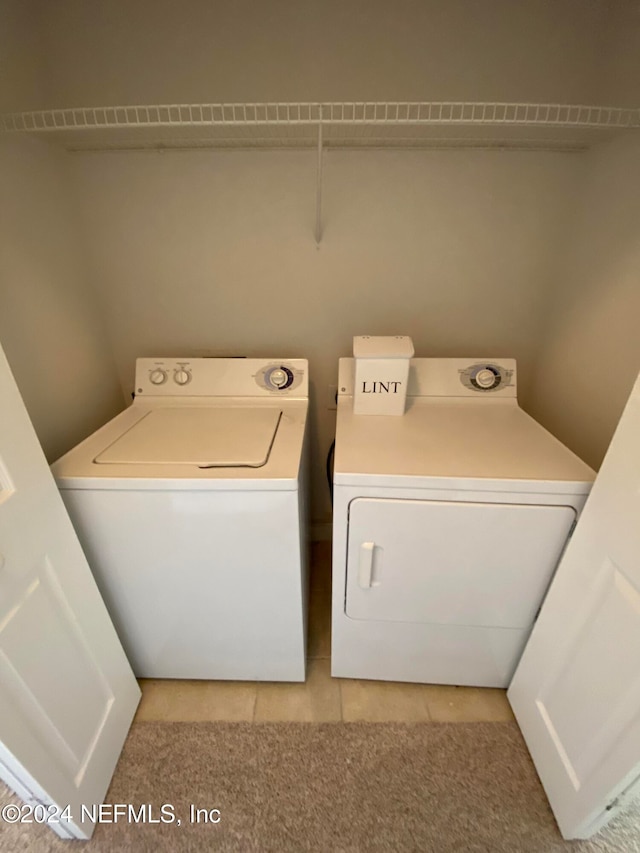 washroom featuring washing machine and clothes dryer and light tile patterned floors