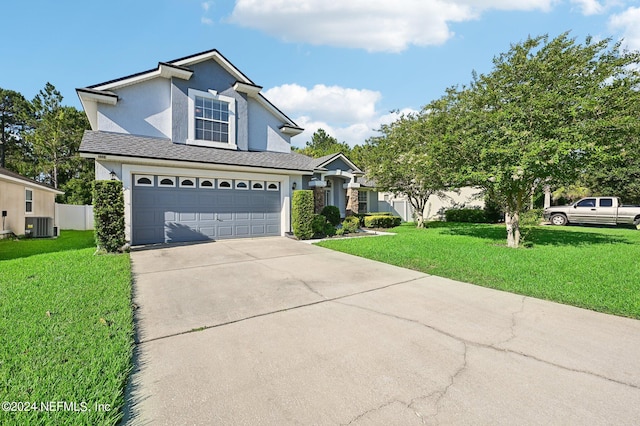 view of property with a garage, a front lawn, and central AC unit