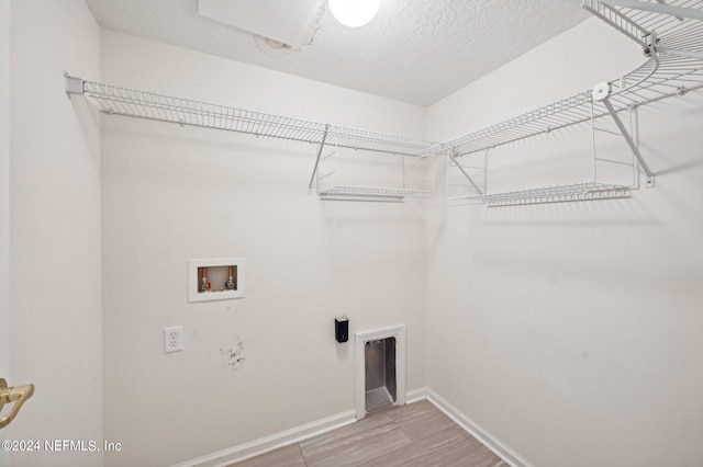 laundry room featuring wood-type flooring, a textured ceiling, and washer hookup