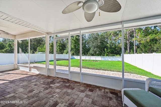 unfurnished sunroom with ceiling fan