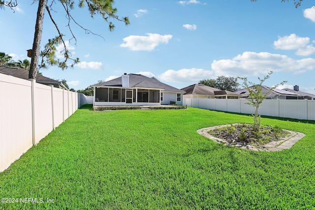 rear view of property featuring a sunroom and a lawn