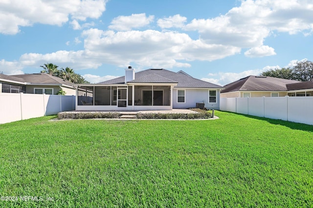 rear view of property with central AC, a sunroom, and a lawn