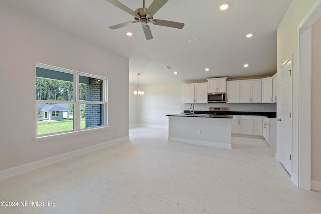 kitchen featuring sink, a center island with sink, white cabinetry, electric range, and ceiling fan with notable chandelier