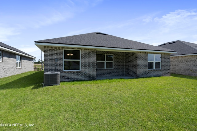 rear view of house featuring central AC unit, a lawn, and a patio