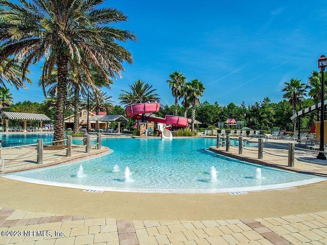 view of swimming pool featuring a water slide and pool water feature