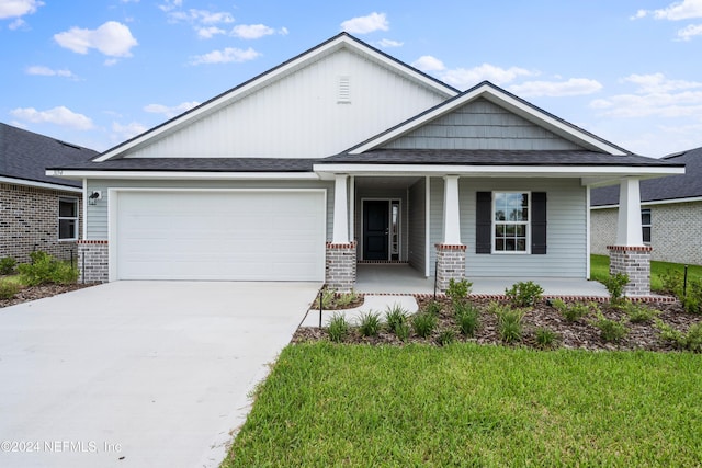 craftsman-style home featuring a front yard, a garage, and a porch