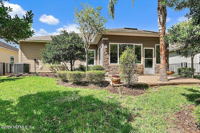 rear view of property with a patio area, central AC, and a lawn