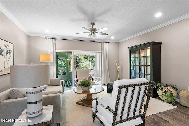 living room with a textured ceiling, crown molding, and wood-type flooring