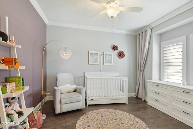 bedroom featuring crown molding, a nursery area, dark hardwood / wood-style floors, and ceiling fan