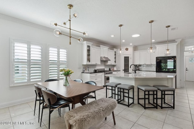 tiled dining space featuring ornamental molding and sink