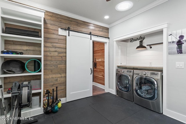 laundry room with a barn door, laundry area, crown molding, baseboards, and washer and dryer