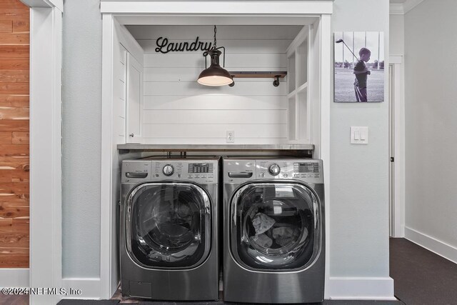 washroom with ornamental molding, independent washer and dryer, and wood walls