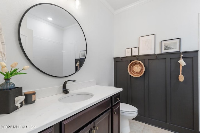 bathroom with toilet, vanity, ornamental molding, and tile patterned flooring
