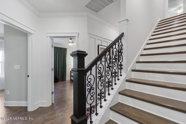 staircase with ceiling fan, crown molding, visible vents, baseboards, and wood finished floors