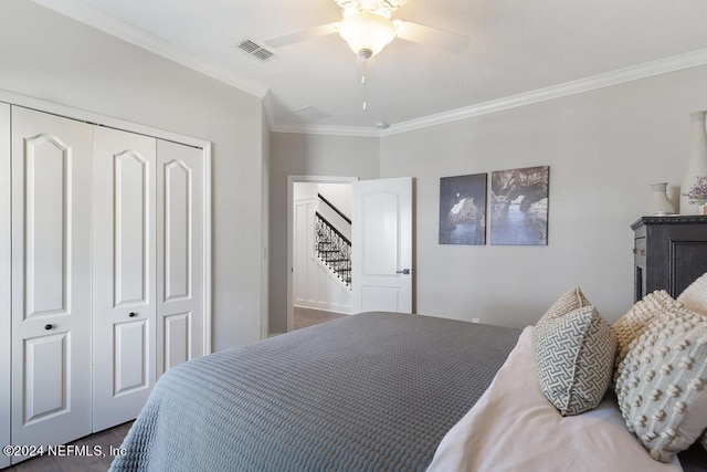 bedroom with visible vents, ceiling fan, a closet, ornamental molding, and dark wood-type flooring