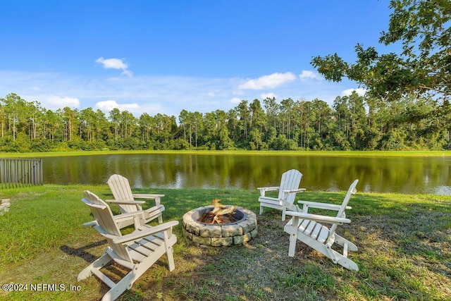 dock area featuring a wooded view, a fire pit, and a water view