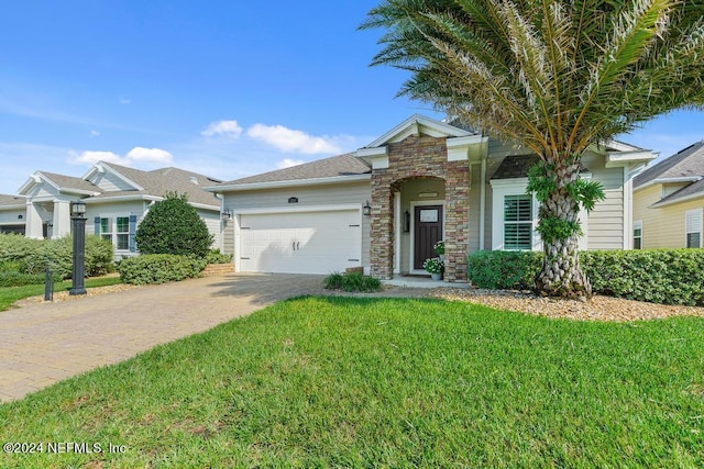view of front of home featuring a front lawn, driveway, stone siding, and a garage