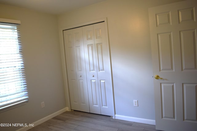 unfurnished bedroom featuring light hardwood / wood-style flooring and a closet