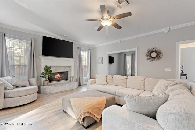 living room with crown molding, ceiling fan, and light hardwood / wood-style floors