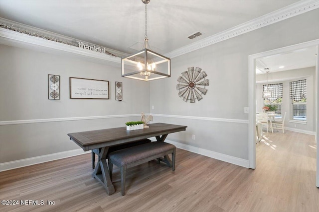 dining room featuring hardwood / wood-style flooring, ornamental molding, a chandelier, and breakfast area