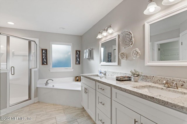 bathroom with vanity and shower with separate bathtub