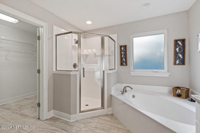 bathroom featuring shower with separate bathtub