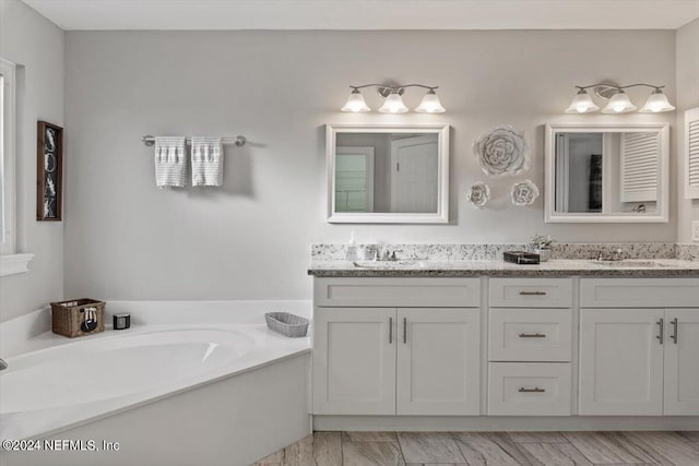 bathroom with a washtub and vanity