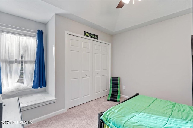 bedroom with ceiling fan, carpet flooring, and a closet