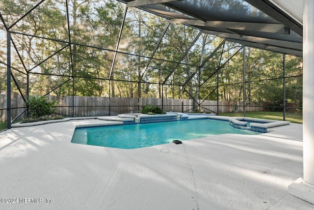 view of swimming pool with a lanai, a patio, and an in ground hot tub