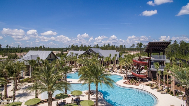 view of swimming pool featuring a water slide and a patio area