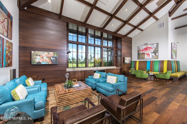 interior space with hardwood / wood-style flooring, beam ceiling, high vaulted ceiling, and wood walls