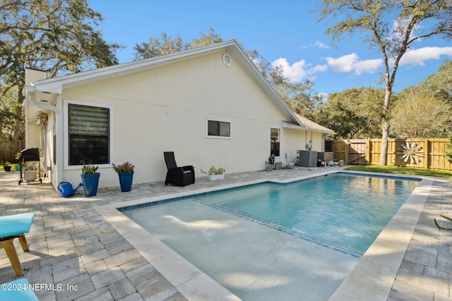 view of pool featuring a patio area, area for grilling, and central AC unit