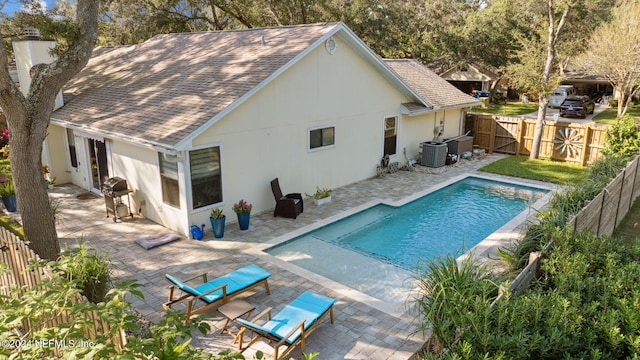 view of swimming pool with central AC, area for grilling, and a patio area