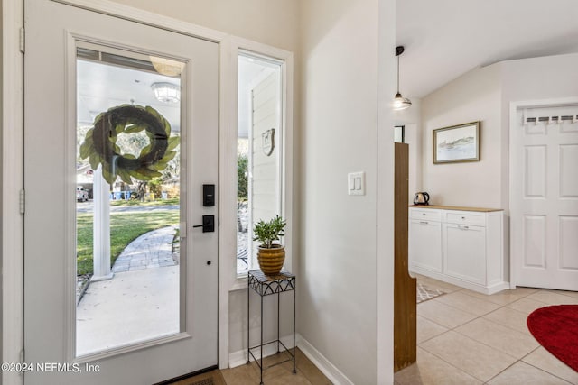 foyer with lofted ceiling and light tile patterned floors