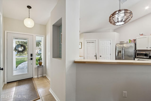 entrance foyer featuring vaulted ceiling and light tile patterned flooring