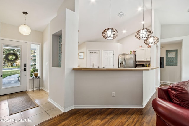 entrance foyer with wood-type flooring and vaulted ceiling