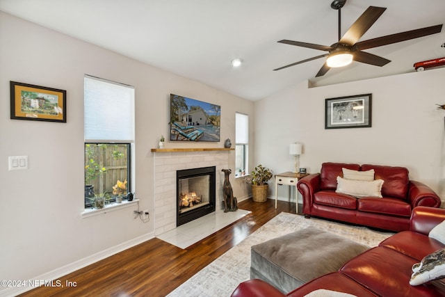 living room featuring lofted ceiling, ceiling fan, a brick fireplace, and dark hardwood / wood-style flooring