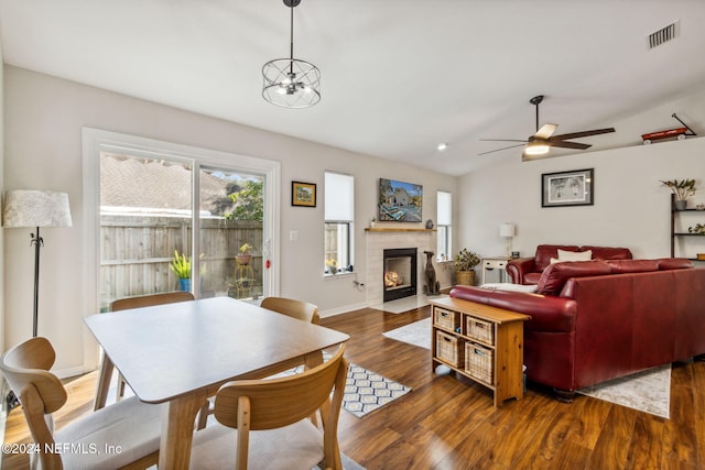 living room featuring lofted ceiling, dark wood-type flooring, and ceiling fan with notable chandelier