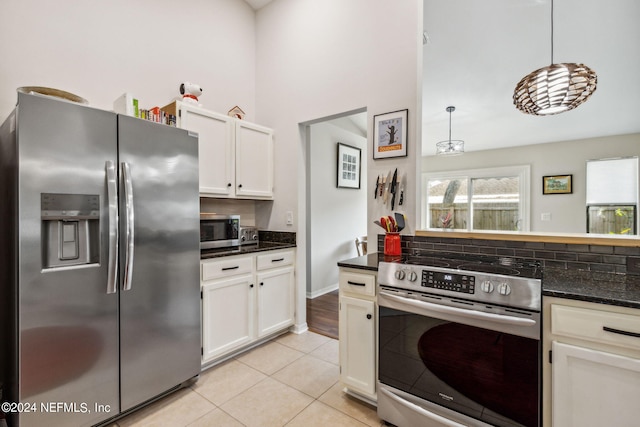 kitchen with white cabinets, tasteful backsplash, light tile patterned floors, appliances with stainless steel finishes, and pendant lighting