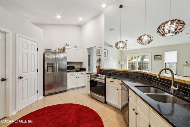 kitchen with sink, appliances with stainless steel finishes, decorative light fixtures, and decorative backsplash